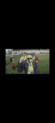 a group of people standing on a field with the words " we worden genoaid " on the bottom right