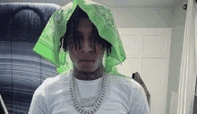 a man wearing a green bandana on his head is standing in a room .