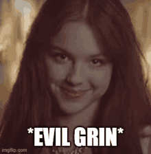 a close up of a woman 's face with the words " evil grin " written below her