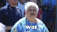 an elderly woman wearing a blue shirt with the word wat written on it