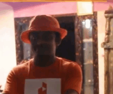 a man wearing a hard hat and an orange shirt is holding a card .