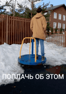 a man is standing on a merry go round in the snow with a fence in the background and the words " poplach ob tom " below