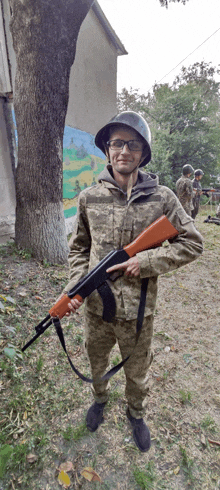 a man in a military uniform holds a gun and points at it