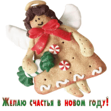 a gingerbread angel is holding a christmas tree and candy