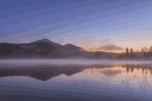 a foggy lake with a mountain in the background