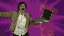 a man in a brown jacket is holding a laptop in front of a purple background