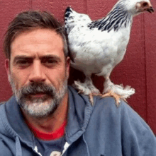 a man with a chicken on his shoulder .