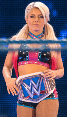 a woman in a wrestling ring with a blue belt that says ' wwe ' on it