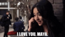 a woman is talking on a cell phone and says i love you maya