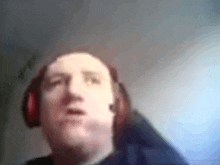 a man wearing headphones is making a funny face in a blurry photo .