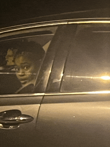 a woman is sitting in a car with her head out the window