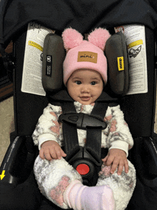 a baby wearing a pink hat that says mini