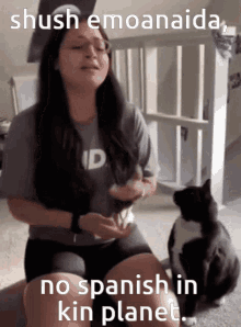 a woman sitting next to a black and white cat with a caption that says shush emoanaida no spanish in kin planet