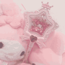 a stuffed animal with a pen that says ' hello kitty ' on it