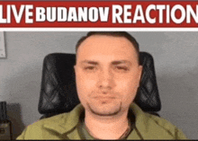 a man is sitting in a chair in front of a live budenov reaction sign