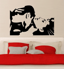 a silhouette of a man kissing a woman on a wall above a bed