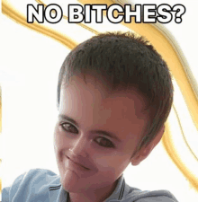 a young boy with a big head is making a funny face and the words no bitches are above him .