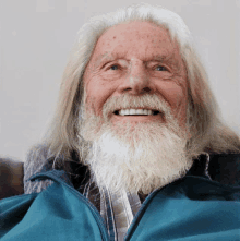 a man with long hair and a white beard is smiling for the camera