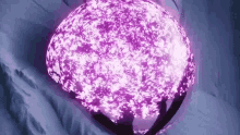 a purple sphere with a purple light coming out of it is floating in the air .