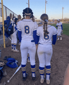 two female softball players with the number 8 and 6 on their jerseys