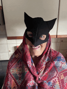 an elderly woman wearing a cat mask and a scarf around her neck