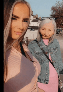 two women standing next to each other with one wearing a pink shirt