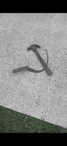 a hammer and sickle on a sidewalk with grass in the background