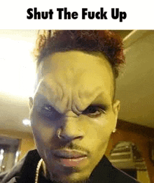 a close up of a man 's face with a caption that says shut the fuck up .