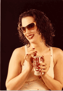 a woman wearing sunglasses is drinking diet coke