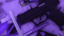 a black gun is sitting on top of a purple blanket next to a lighter .