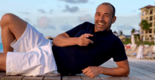 a man in a hurley shirt is laying on a wooden deck