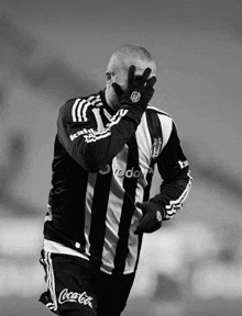 a soccer player wearing a black and white striped jersey with coca-cola written on the shorts