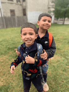 a boy in a nike jacket is carrying another boy