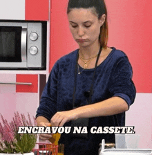 a woman in a kitchen with the words engravou na cassete written above her