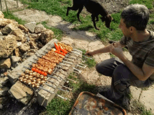 a man is cooking food on a grill with a dog in the background