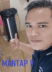 a man is giving a thumbs up in front of a fan and the word mantap is on the bottom