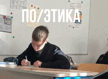 a boy sits at a desk in front of a white board that says " po / ettika "