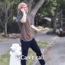 a man talking on a cell phone while standing next to a white fire hydrant that says can 't call