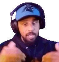 a man wearing headphones and a panthers hat looks surprised