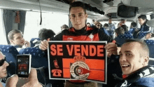 a man on a bus holds up a sign that says se vende