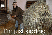 a woman is carrying a large pile of hay with the words i 'm just kidding below her