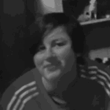 a black and white photo of a woman wearing a red adidas shirt .