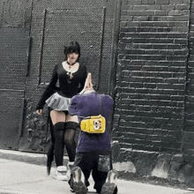 a woman in a skirt is standing next to a man in a purple shirt with a spongebob bag on his back