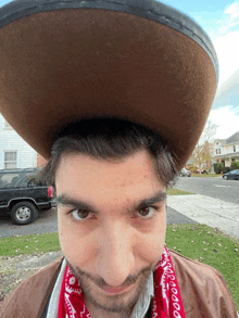 a man wearing a brown hat and a red bandana