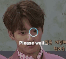 a close up of a young man 's face with a circle around his eye and the words `` please wait '' .