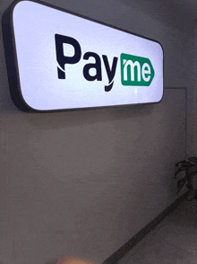 a pay me sign is hanging on a wall