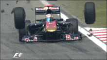 a red bull race car is going down a track with a f1 logo in the corner