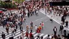 a crowd of people crossing a street including a man wearing a shirt that says ' chicago bulls ' on it