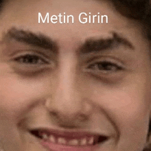 a close up of a man 's face with the words metin girin written above it .