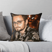 a pillow with a picture of a man wearing glasses